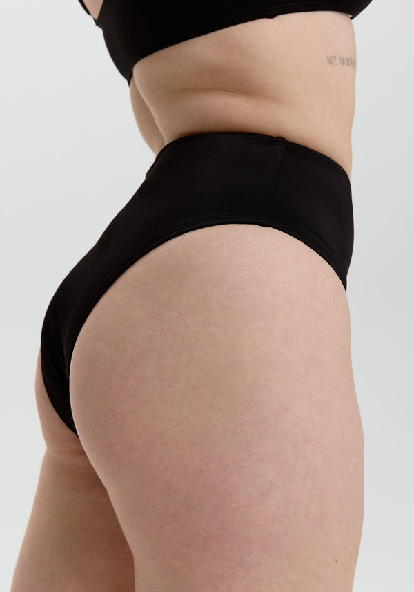 model is wearing an S bikini bottom - black drift high waist bikini bottom