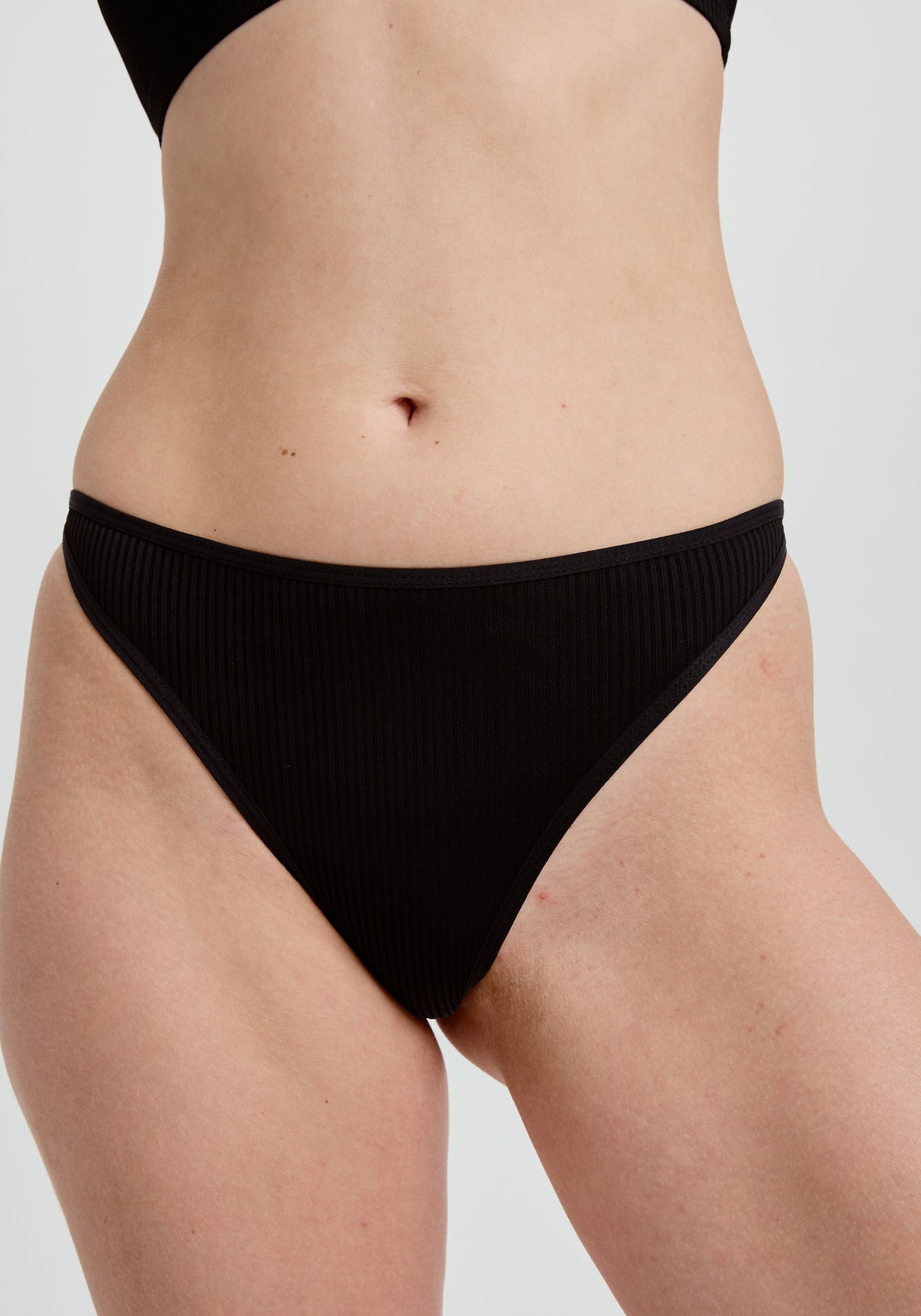model is wearing an S panty - black the rib high leg thong