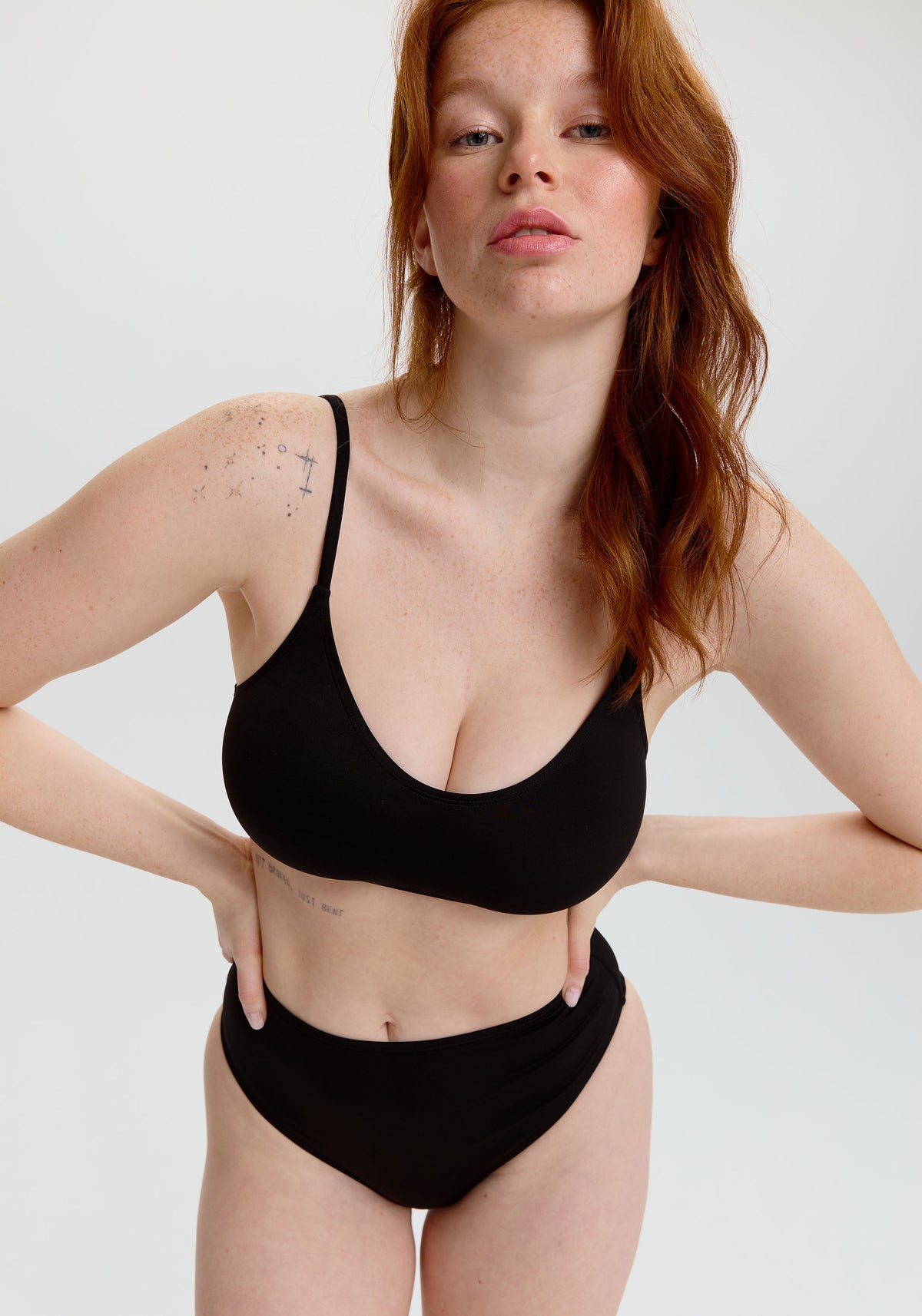 model is wearing an S+ bikini top - black tide scoop bikini top