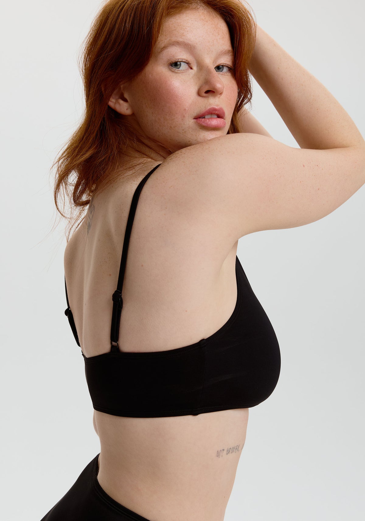 model is wearing an S+ bikini top - black tide scoop bikini top