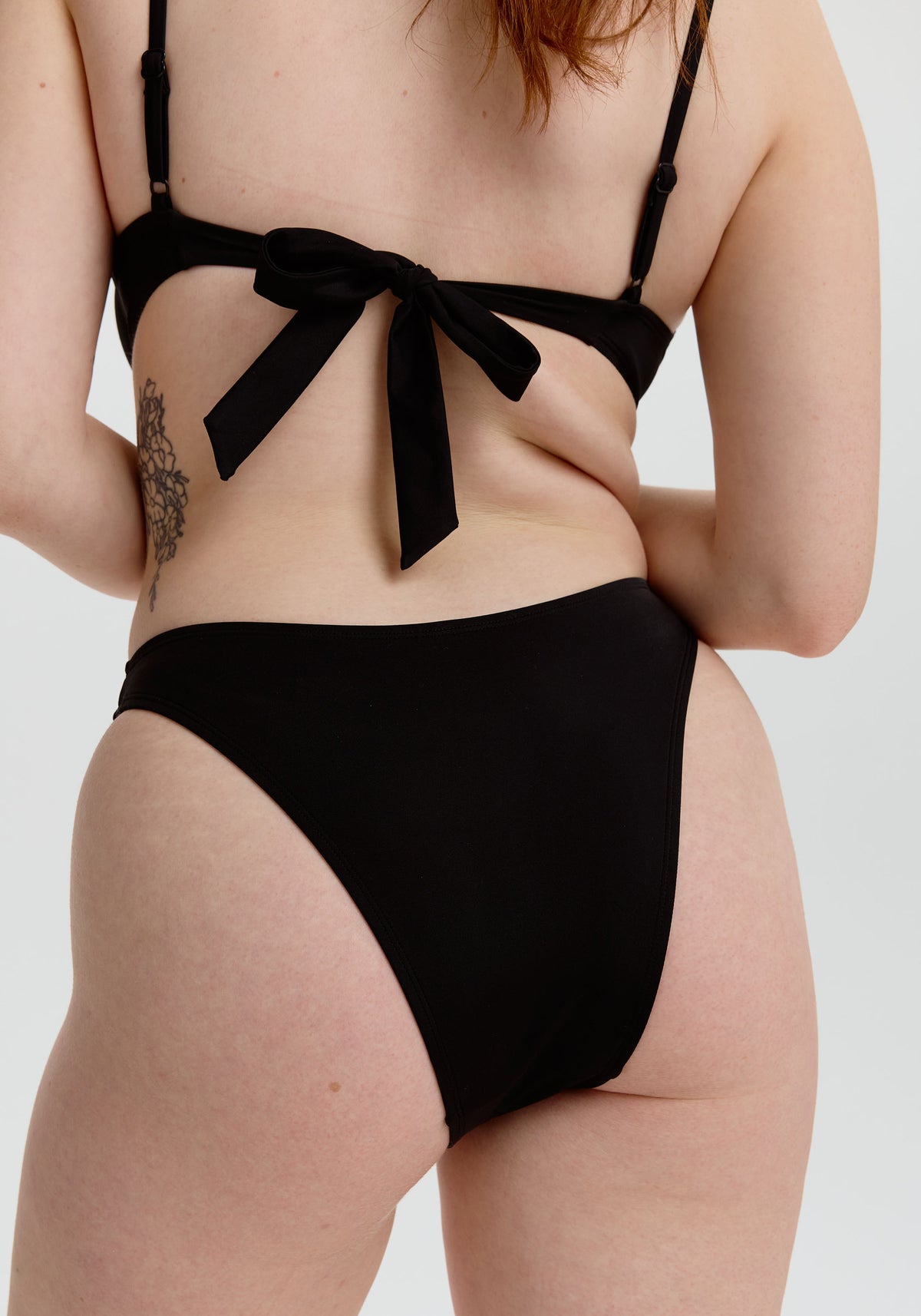 model is wearing an S bikini bottom - black capri high leg bikini bottom
