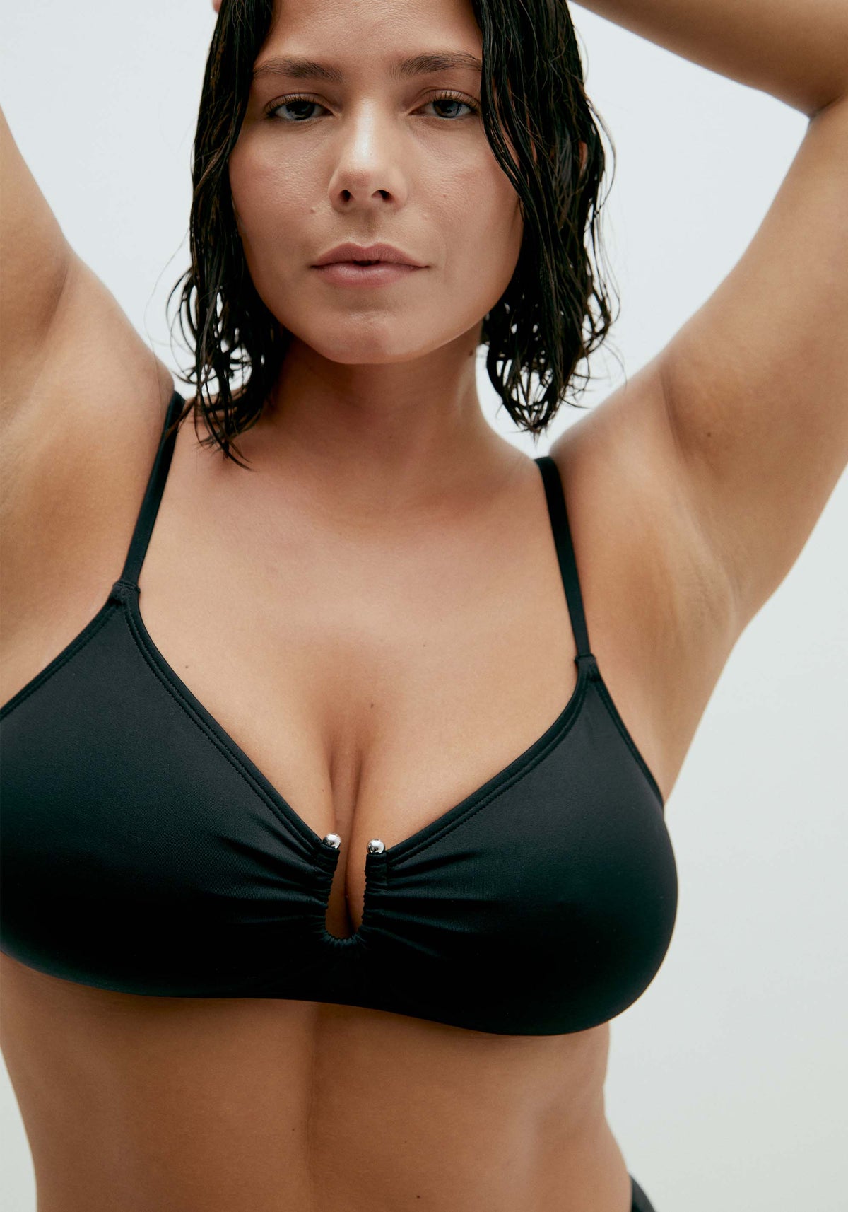 model is wearing an M+ bikini top-black solstice v-scoop bikini top