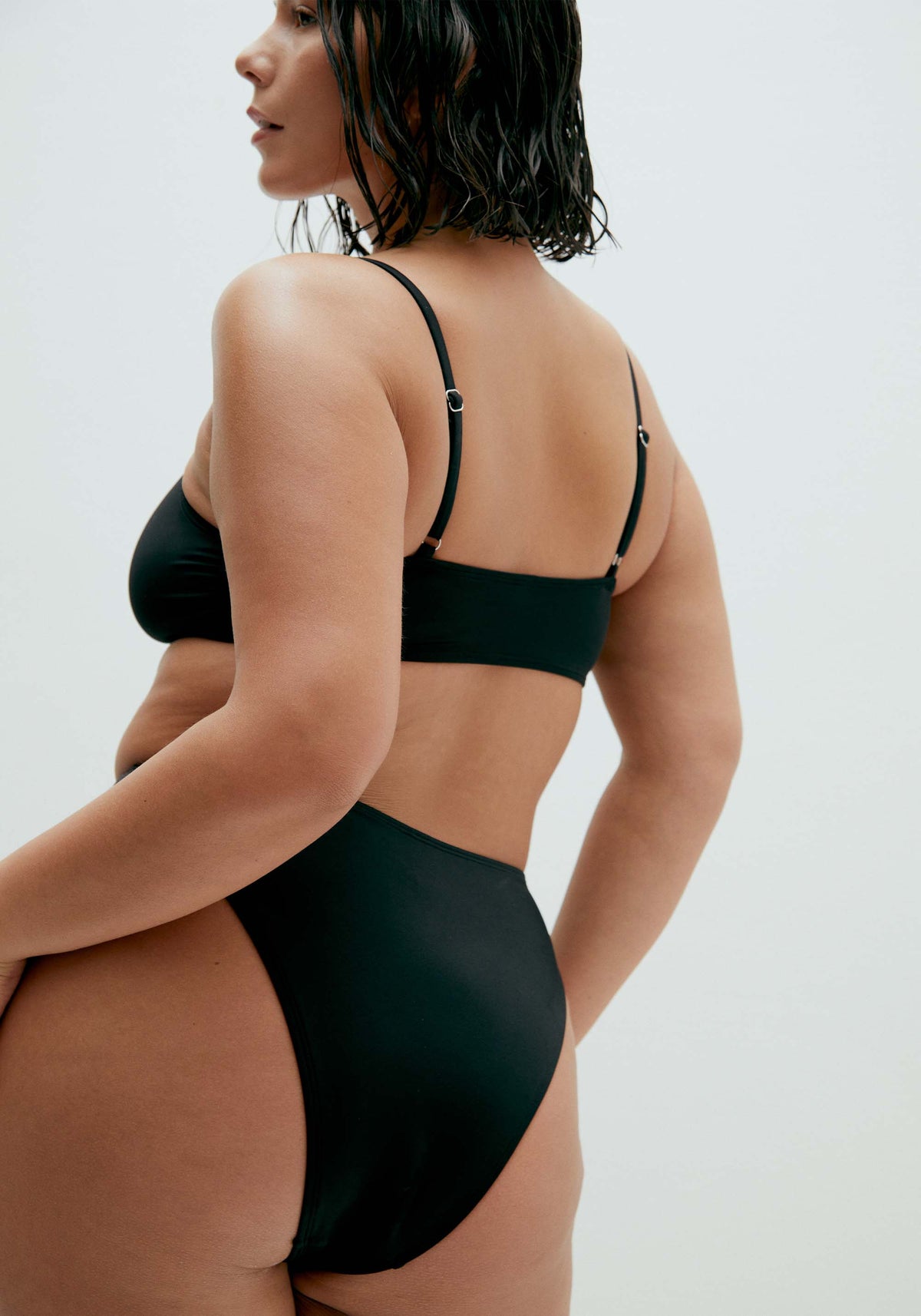 model is wearing an M+ bikini top-black solstice v-scoop bikini top