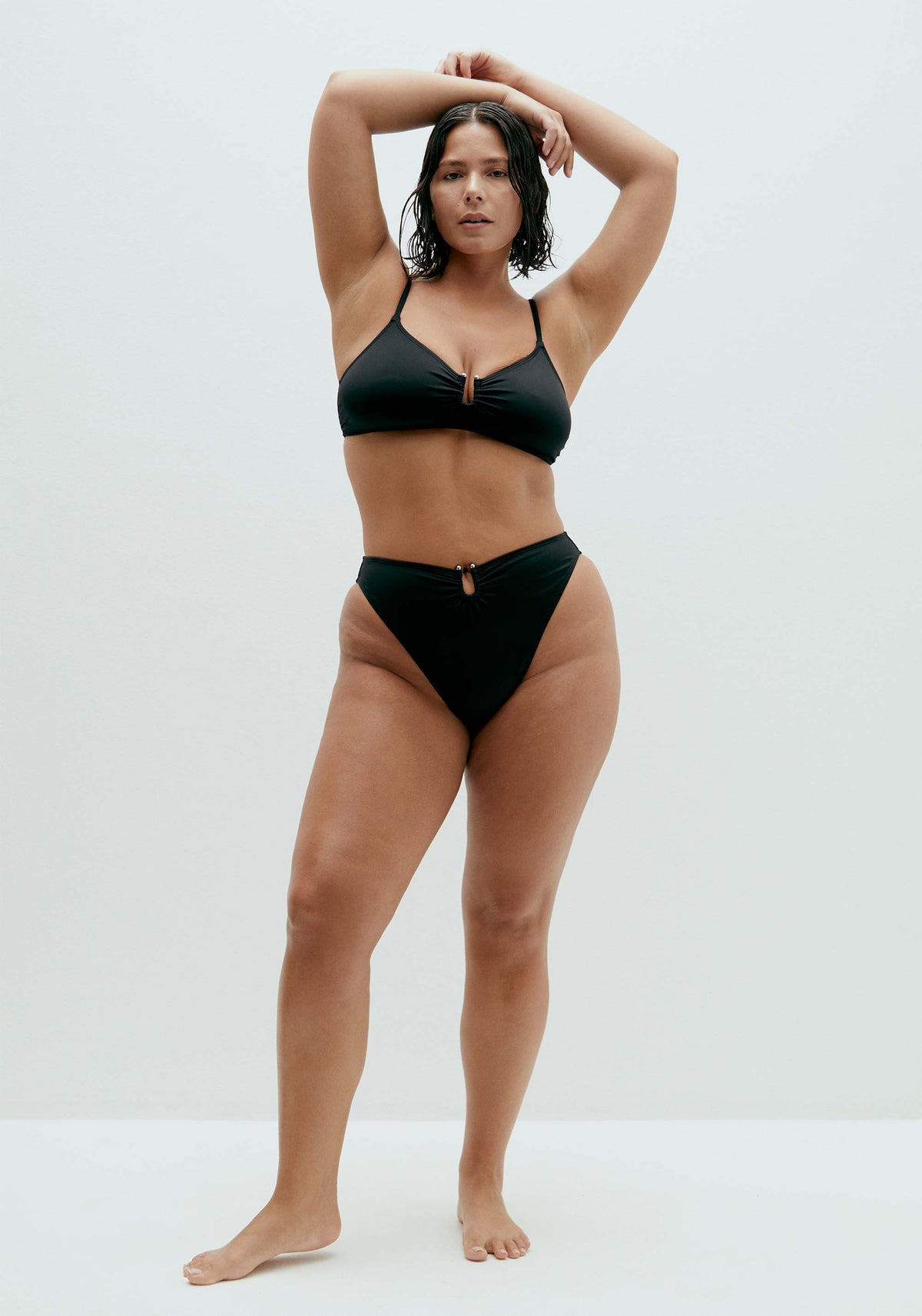 model is wearing an M+ bikini top-black solstice v-scoop bikini top