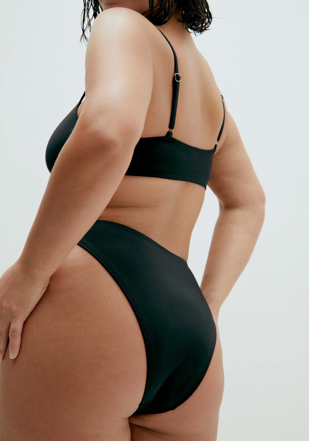 model is wearing an L bikini bottom-black solstice high leg bikini bottom