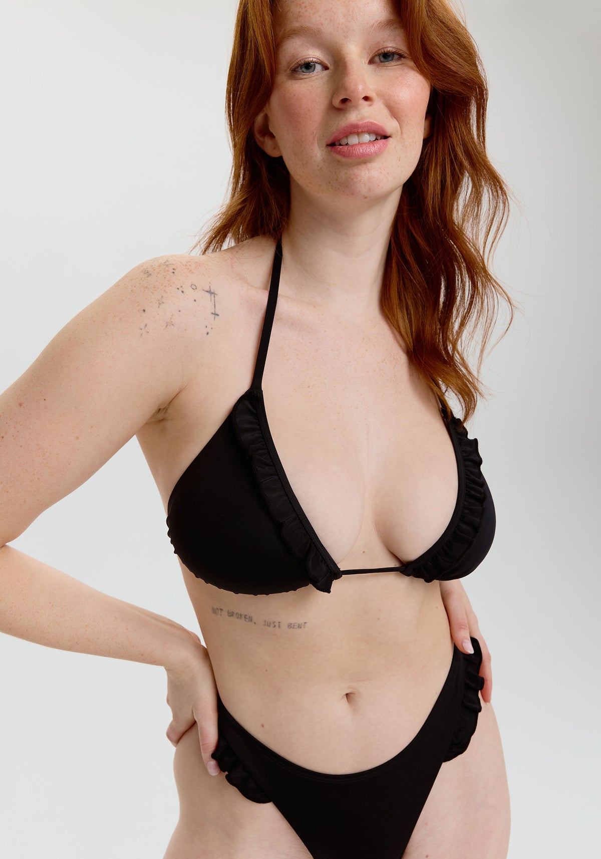 model is wearing an L bikini top - black petra ruffle triangle bikini top
