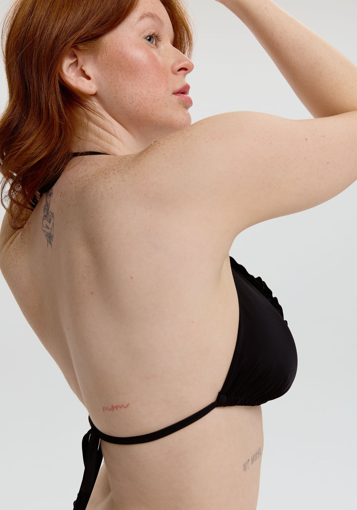 model is wearing an L bikini top - black petra ruffle triangle bikini top