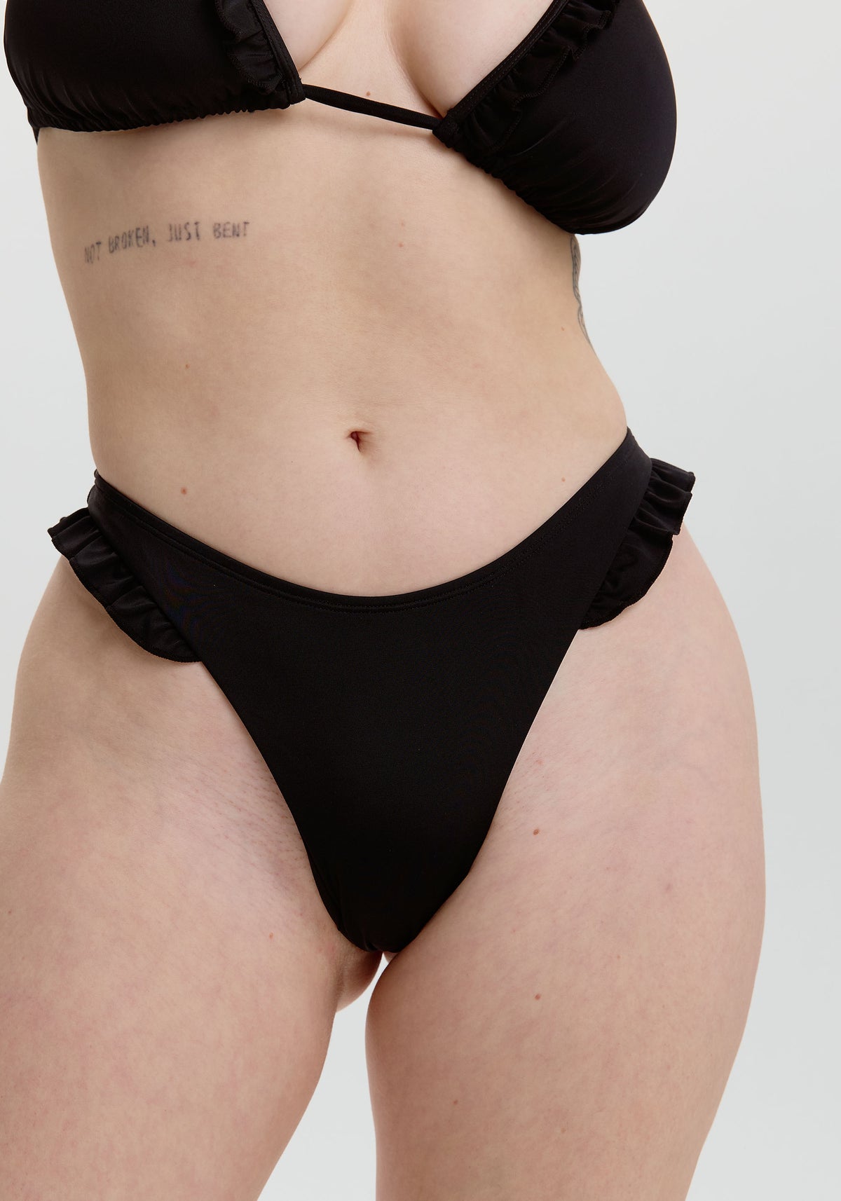 model is wearing an S bikini bottom - black cora ruffle thong bikini bottom