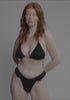 model is wearing an S bikini bottom - black cora ruffle thong bikini bottom